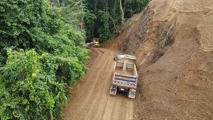 August 2026: dump truck hauling spoil down a new mountain road.