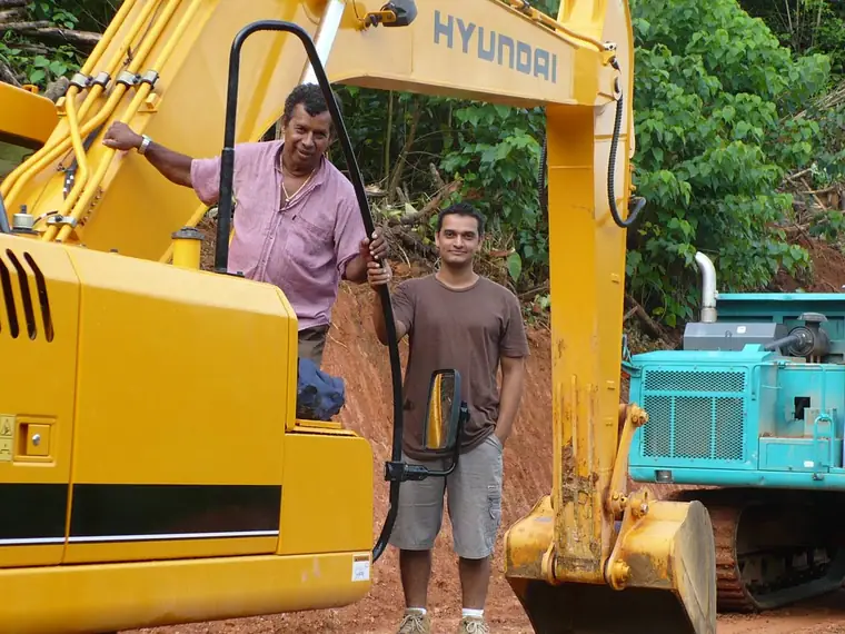 Dos miembros de la cuadrilla junto a la excavadora Hyundai