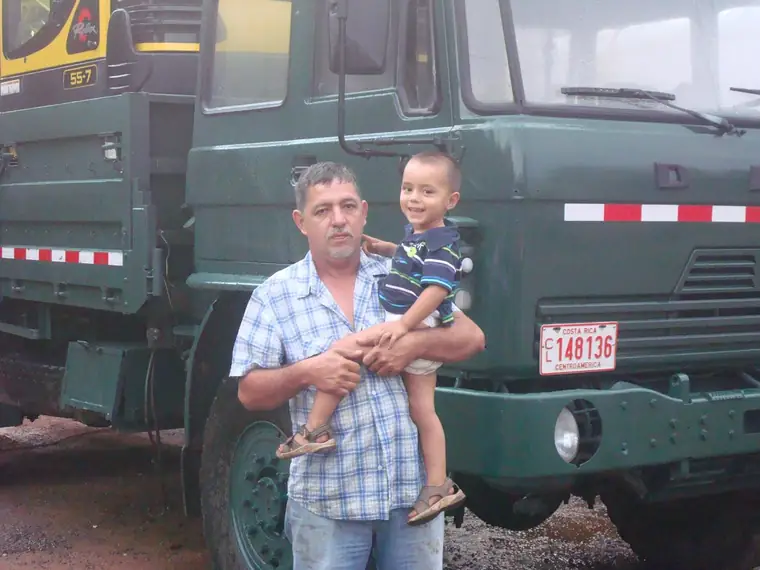 Padre e hijo de la familia Rojas frente a una vagoneta