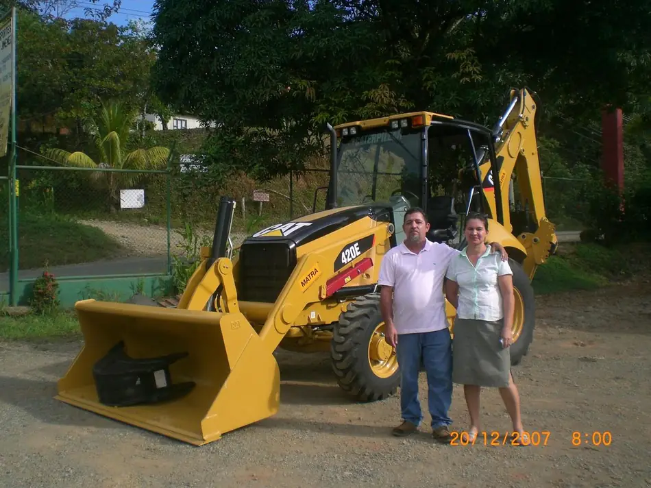 Olman Rojas y su esposa junto a la retroexcavadora Cat 420E